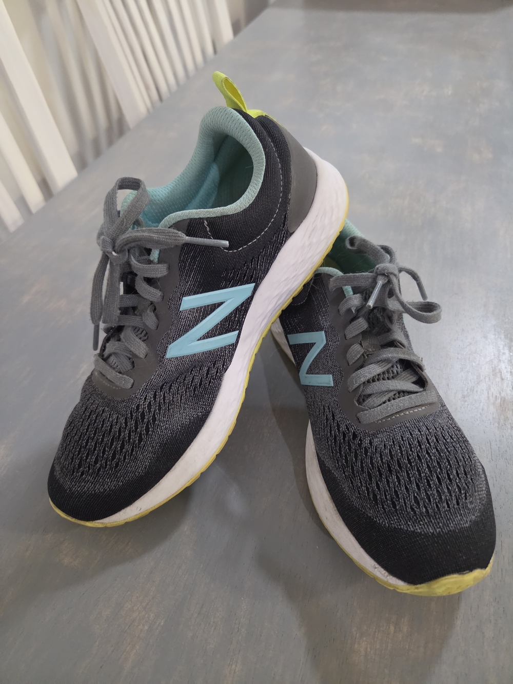 New Balance Dark Gray Running Shoes with Light Blue Logo and Yellow Soles